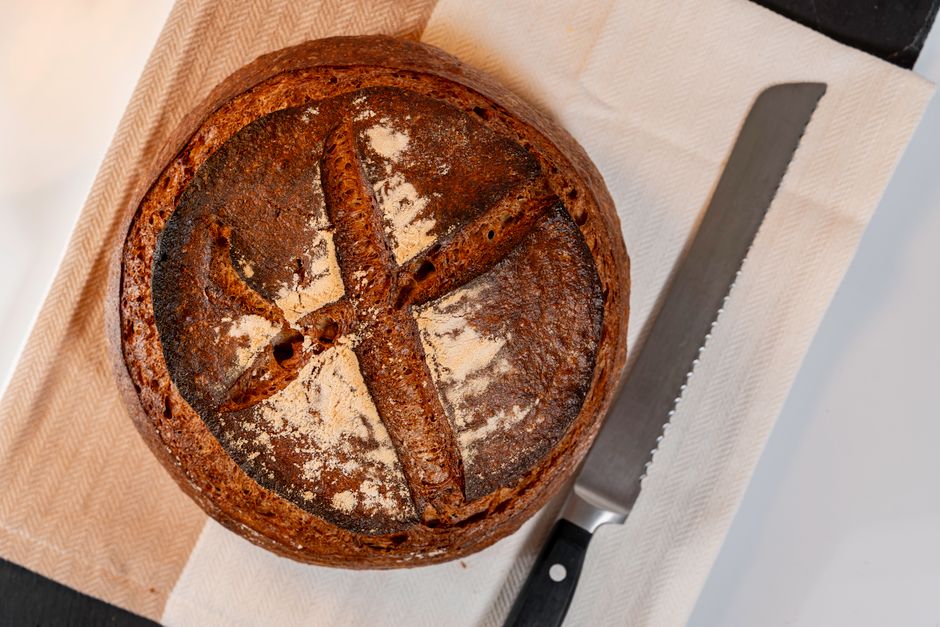 Close-up of a freshly baked artisan sourdough bread loaf with a rustic crust on a cloth wi