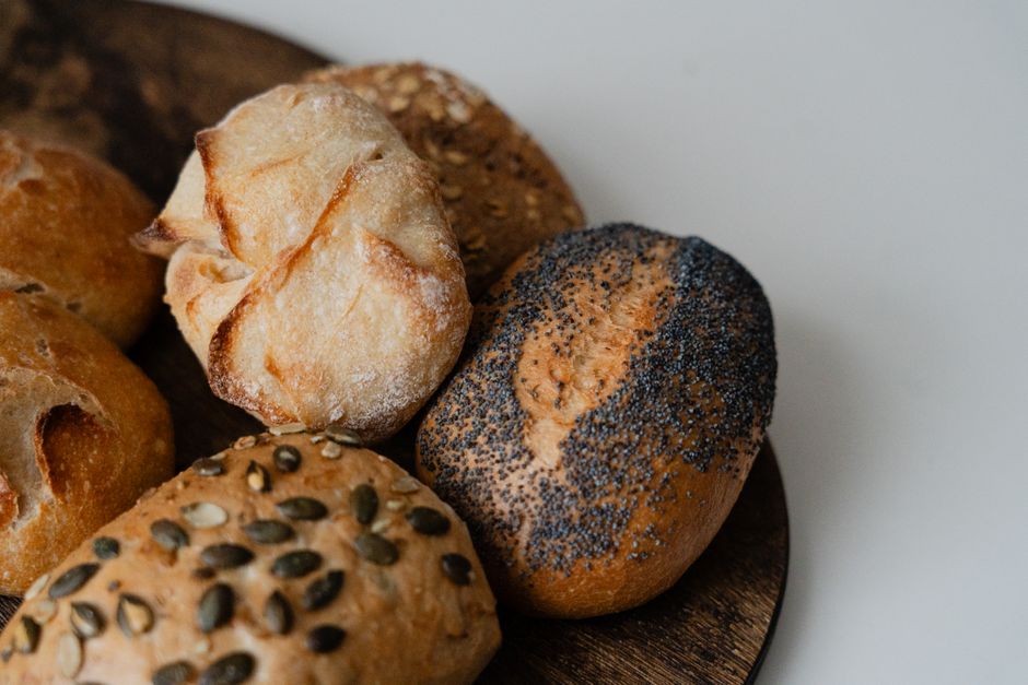 Close-up of various artisan bread rolls with seeds and grains, showcasing texture and variety.
